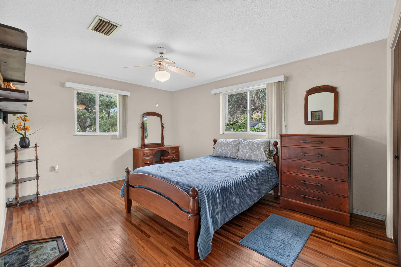 Bedroom with hardwood floors and two windows