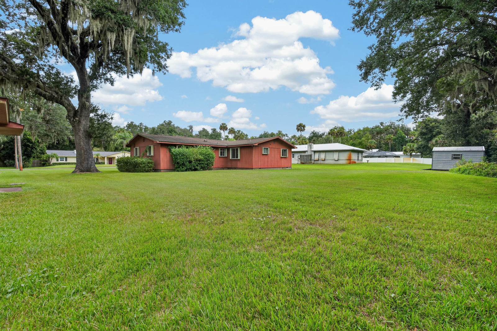 Open green grounds with the home and detached garage